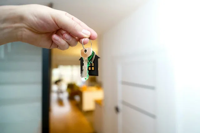 Mão a segurar as chaves de uma casa nova depois de assinar o contrato-promessa de compra e venda