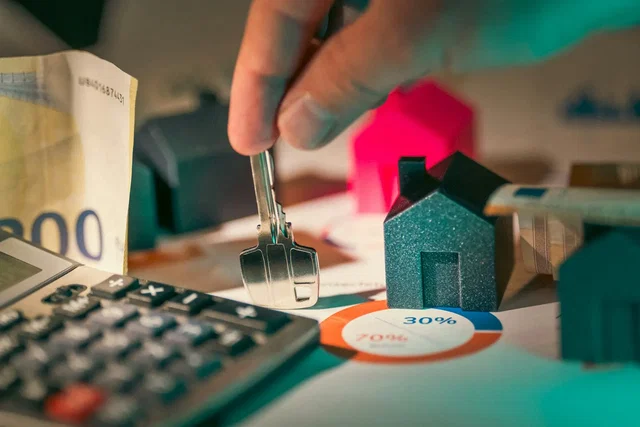 Calculadora, chave e maqueta de casa para calcular a taxa de esforço do crédito à habitação