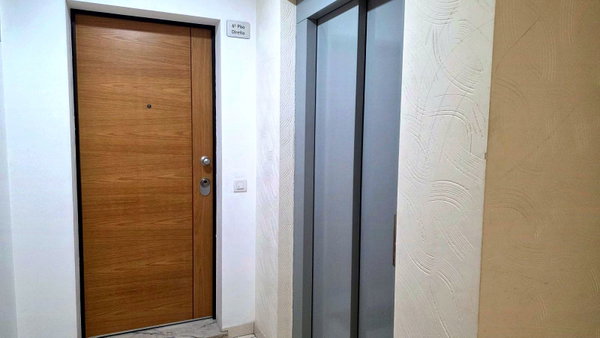 Hall de entrada com porta blindada em madeira e elevador, apartamento T3 em Portimão