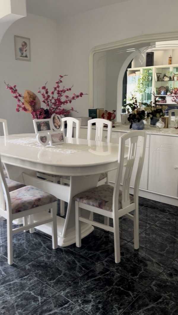 Sala de jantar com mesa e cadeiras brancas e piso escuro, apartamento T3 em Portimão