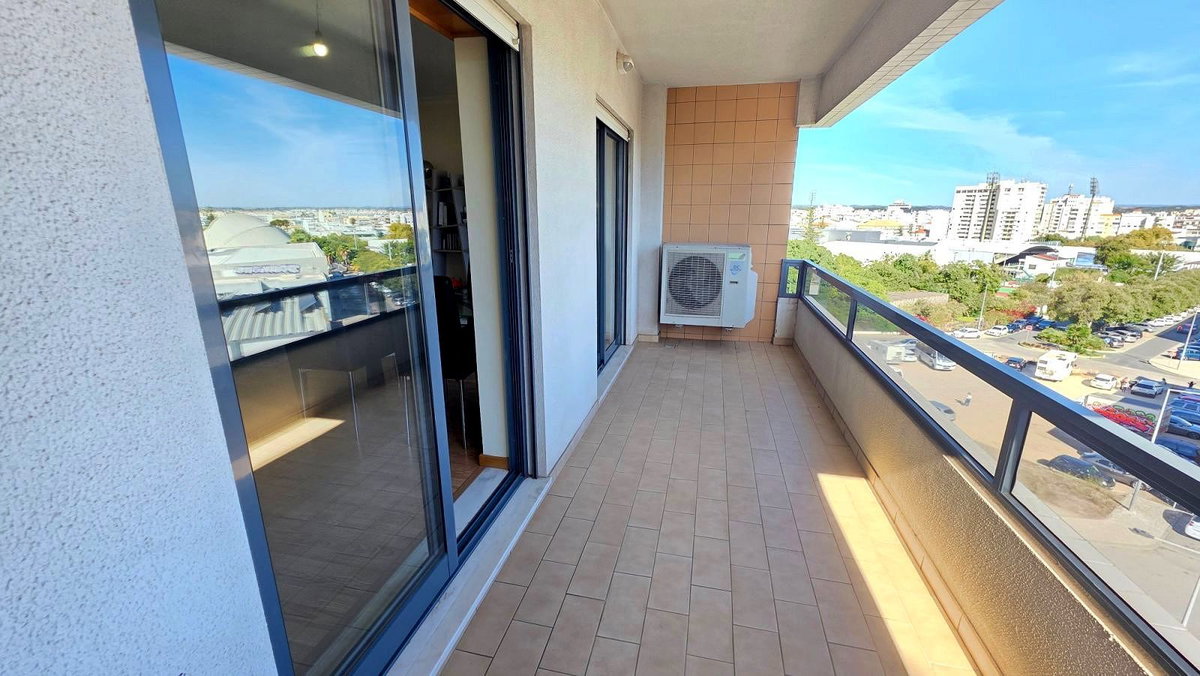 Varanda comprida com pavimento cerâmico e vista para a cidade, apartamento T3 em Portimão
